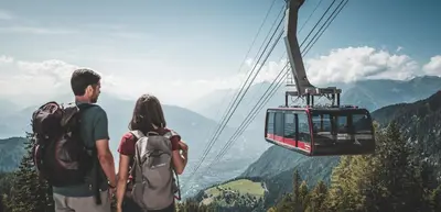 a couple standing on top of a mountain with a gondola at DER MESNERWIRT - 4 Superior - Meraner Land in Avelengo