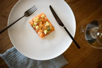 a piece of food on a white plate with a fork and knife at DER MESNERWIRT - 4 Superior - Meraner Land in Avelengo