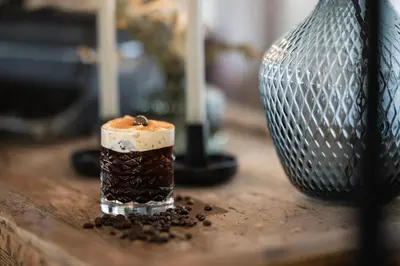 a small glass cup filled with coffee sitting on a table at DER MESNERWIRT - 4 Superior - Meraner Land in Avelengo