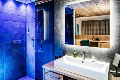 a bathroom with a white sink and blue tiles at DER MESNERWIRT - 4 Superior - Meraner Land in Avelengo