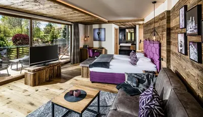 a hotel room with a bed and a balcony at DER MESNERWIRT - 4 Superior - Meraner Land in Avelengo