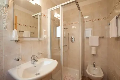a bathroom with a sink and a shower at Hotel Jú Furcia in San Vigilio Di Marebbe