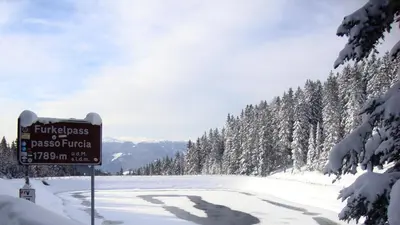 a sign on the side of a snow covered road at Hotel Jú Furcia in San Vigilio Di Marebbe