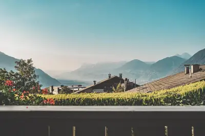 a view of mountains from a balcony with flowers at Hotel Turmwies in Tirolo
