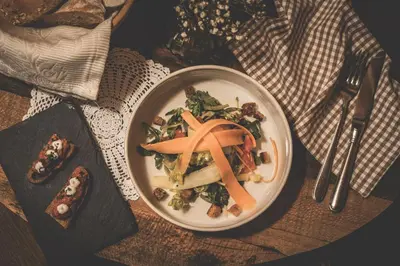 a plate of food with carrots on a table at Hotel Turmwies in Tirolo