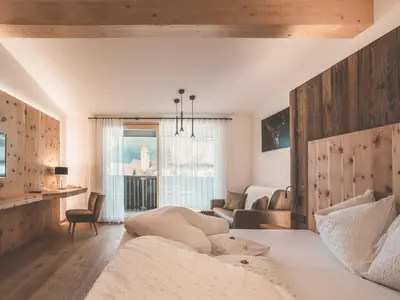 a bedroom with a bed and a living room at Hotel Turmwies in Tirolo