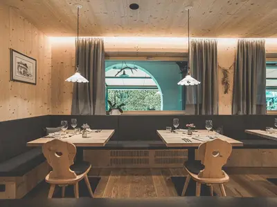 a restaurant with two tables and chairs and a window at Hotel Turmwies in Tirolo