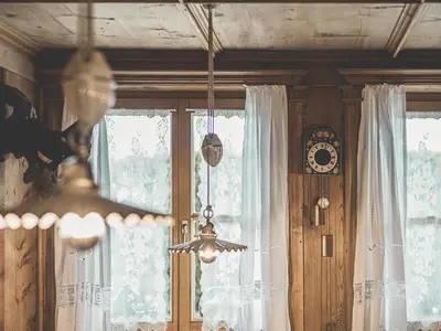 a chandelier in a room with a window and a clock at Hotel Turmwies in Tirolo