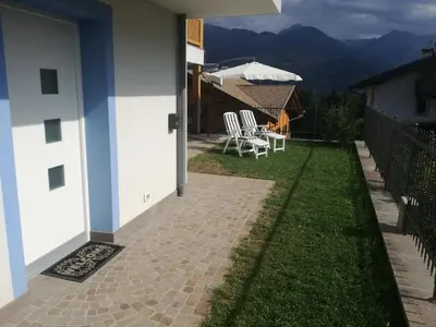 a patio with chairs and an umbrella on a house at Villa in Val di Fiemme in Cavalese