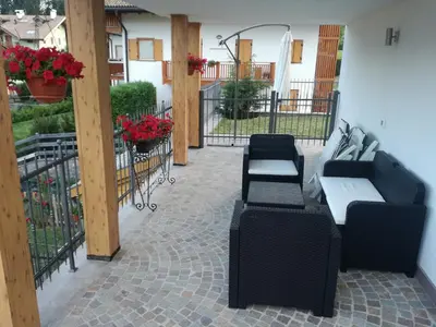 a patio with two couches and a table and chairs at Villa in Val di Fiemme in Cavalese