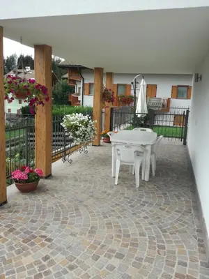 a patio with a white table and some flowers at Villa in Val di Fiemme in Cavalese