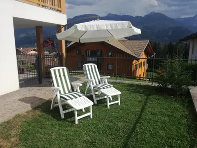 two chairs and a table with an umbrella at Villa in Val di Fiemme in Cavalese