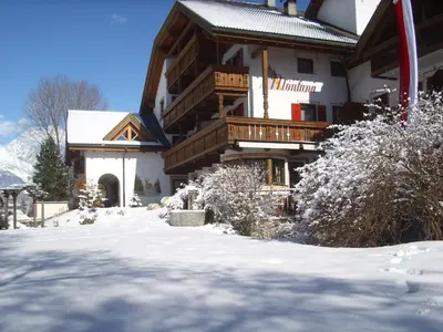 a large building with snow on the ground at Apartments Residence Montana in Rasun di Sopra