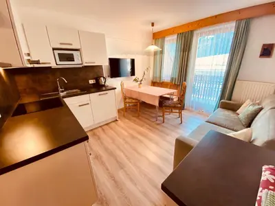 a kitchen and living room with a couch and a table at Apartments Residence Montana in Rasun di Sopra
