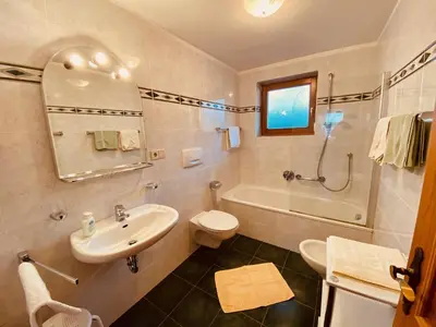 a bathroom with a sink and a toilet and a tub at Apartments Residence Montana in Rasun di Sopra