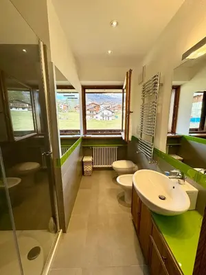 a bathroom with two toilets and a sink and a shower at Charme alpino e modernità-Appartamento ristrutturato a due passi dal centro in Cortina dʼAmpezzo