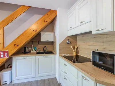 a kitchen with white cabinets and a microwave on a counter at Apartment Penia 2-3 by Interhome in Canazei