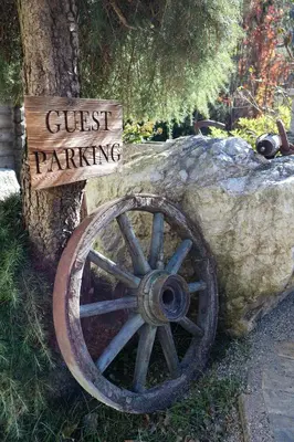 a wooden sign sitting next to a wheel next to a tree at Apartment Wörer in Perca