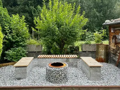 a garden with a fire pit and two benches at Apartment Wörer in Perca