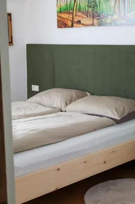 a bed in a room with a green wall at Apartment Wörer in Perca
