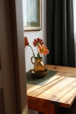 a table with a vase with flowers on it at Apartment Wörer in Perca