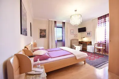 a bedroom with a bed and a living room at Ansitz Wendelstein in Appiano sulla Strada del Vino