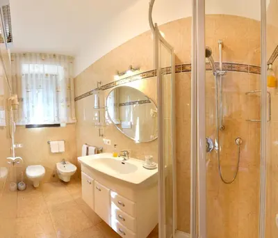 a bathroom with a sink and a shower with a mirror at Ansitz Wendelstein in Appiano sulla Strada del Vino