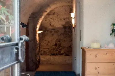 a hallway to a room with a stone wall at Ansitz Wendelstein in Appiano sulla Strada del Vino