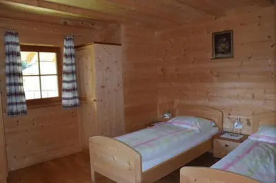 a bedroom with a bed in a log cabin at Ortlerhof im Ultental - Urlaub auf dem Bauernhof in Ultimo