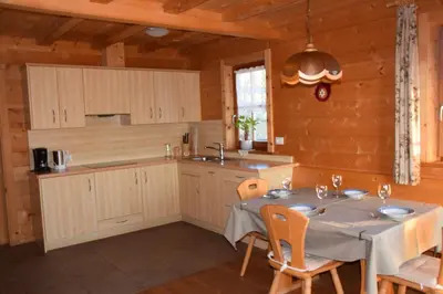 a dining room with a table and a kitchen at Ortlerhof im Ultental - Urlaub auf dem Bauernhof in Ultimo