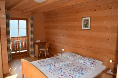 a bedroom with a bed in a log cabin at Ortlerhof im Ultental - Urlaub auf dem Bauernhof in Ultimo