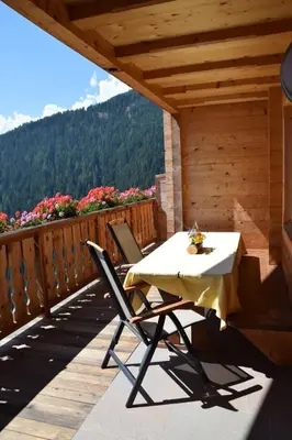 a table and chairs on a deck with a view at Ortlerhof im Ultental - Urlaub auf dem Bauernhof in Ultimo