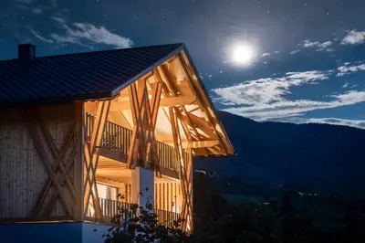 a building with a wooden balcony on the side of it at Steindlgut - Weinberg Chalets in Brixen