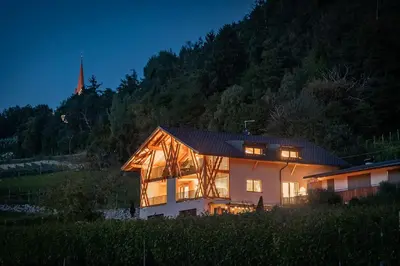 a house with its lights on at night at Steindlgut - Weinberg Chalets in Brixen