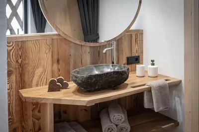 a bathroom with a stone sink and a mirror at Steindlgut - Weinberg Chalets in Brixen
