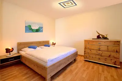 a bedroom with a bed and a wooden dresser at Schienhof in Chiusa