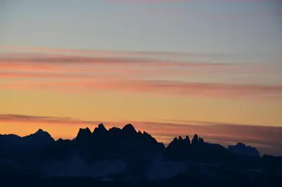 a silhouette of mountains with a sunset in the background at Schienhof in Chiusa