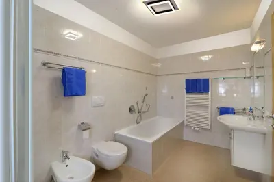 a bathroom with a toilet and a tub and a sink at Schienhof in Chiusa