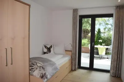 a bedroom with a bed and a sliding glass door at Residence Ladurn in Tirolo