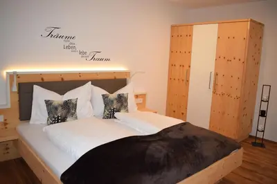 a bedroom with a large bed with white sheets and pillows at Residence Ladurn in Tirolo