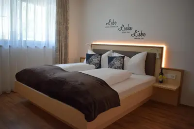 a bedroom with two beds and a sign on the wall at Residence Ladurn in Tirolo