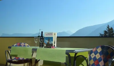 a table and chairs with wine glasses and a book at Residence Ladurn in Tirolo