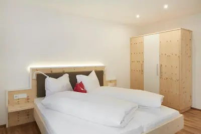 a bedroom with two white beds and a cabinet at Residence Ladurn in Tirolo
