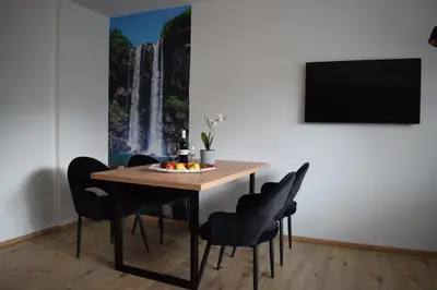 a dining room table and chairs with a waterfall painting on the wall at Residence Ladurn in Tirolo