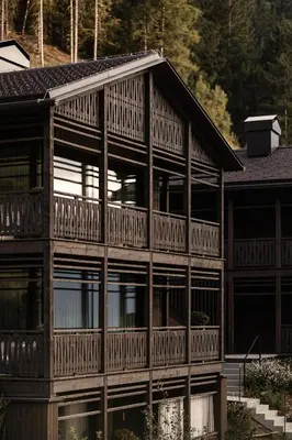 a large wooden house with a balcony at AMONTI Chalets in Molini di Tures
