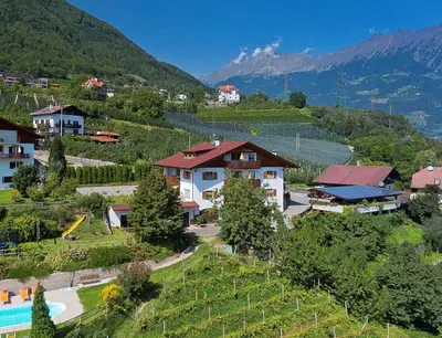 an aerial view of a village with a house and a vineyard at Kircherhof in Marlengo