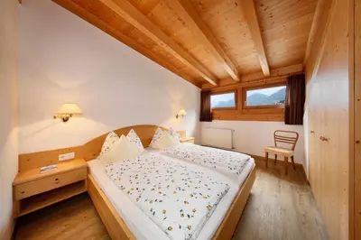 a bedroom with a bed and a wooden ceiling at Kircherhof in Marlengo