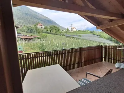 a balcony with a table and a view of a mountain at Kircherhof in Marlengo