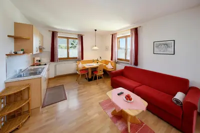 a living room with a red couch and a table at Kircherhof in Marlengo