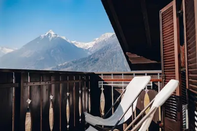 a pair of white chairs on a balcony with mountains at Apartment Steinbach in Schenna